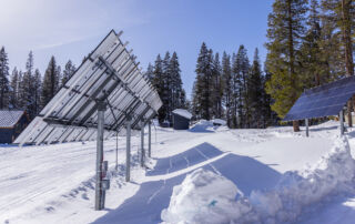 pole mounted solar arrays in a snowy meadow